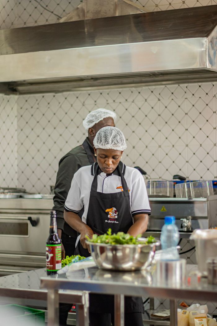 services-03 Two chefs busy preparing dishes in a professional kitchen in Nakuru, Kenya.