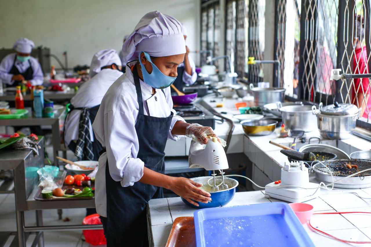 who-we-are Culinary students in Indonesia learn food preparation techniques in a professional kitchen.